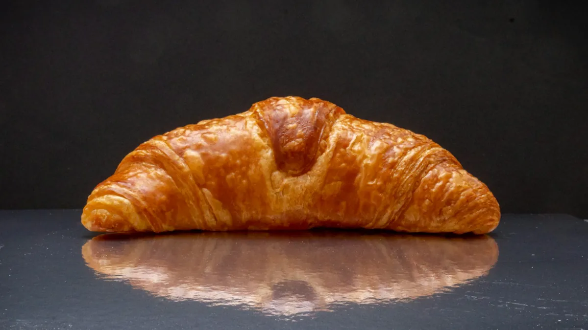 Croissant dorado sobre una superficie oscura brillante