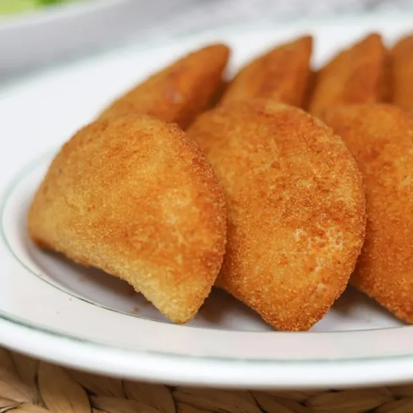 Golden half-moon pasties on a white plate