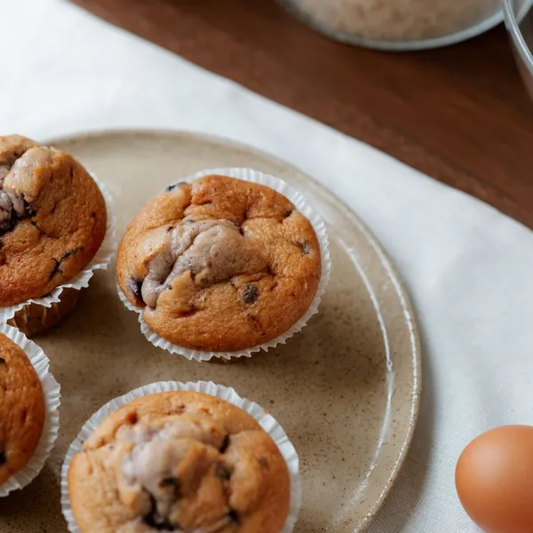 Homemade muffins in paper cases on a ceramic plate